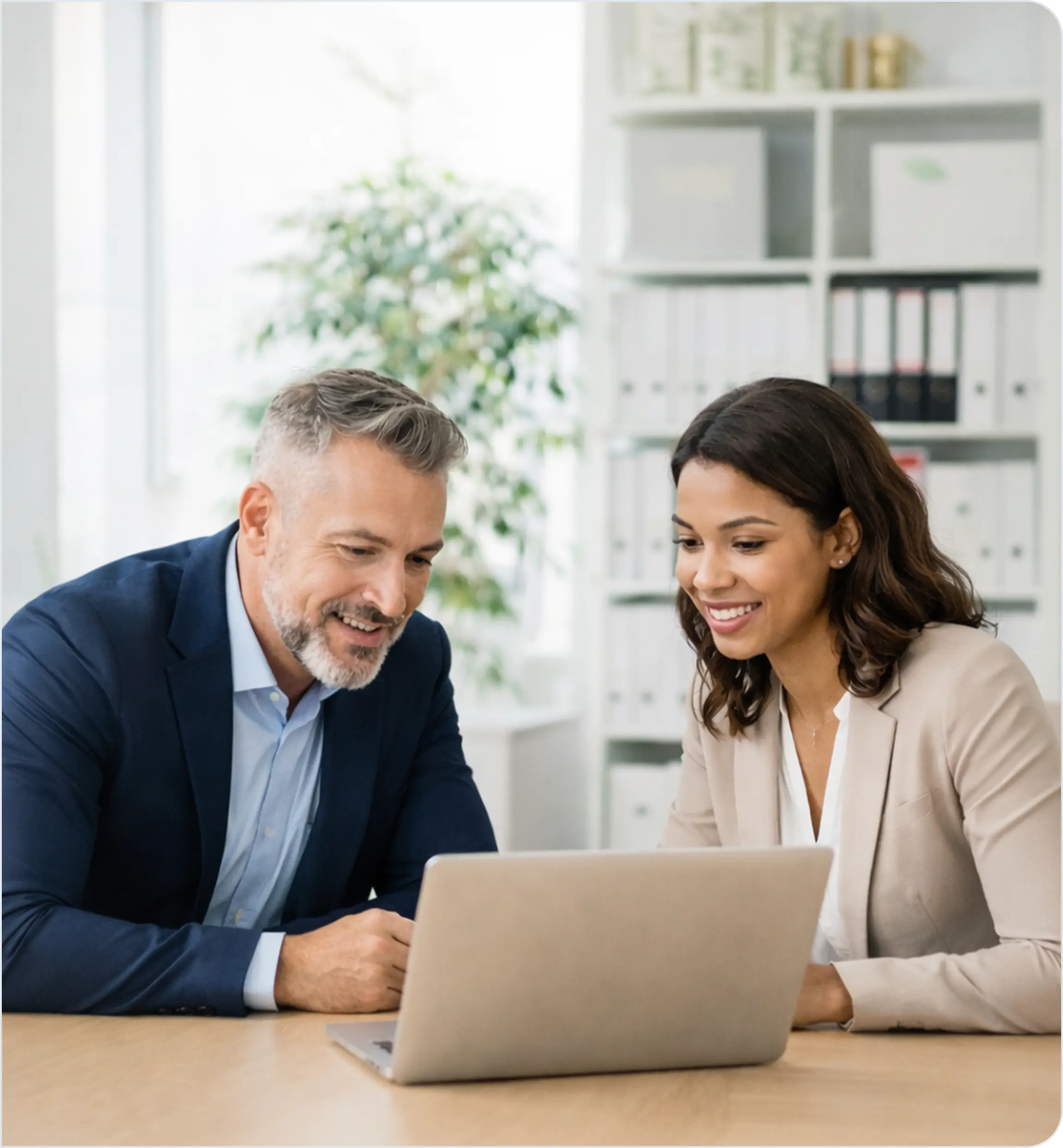 Two professionals reviewing tax and investment data on a laptop.